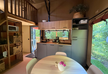 Cucina moderna di lodge e zona pranzo con scala per il soppalco, finestra a Vakantiepark Delftse Hout, Paesi Bassi.
