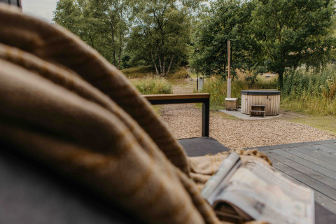 Vista desde la tiny house The Hills en Wilsumer Berge, Alemania, con bañera de hidromasaje y naturaleza.