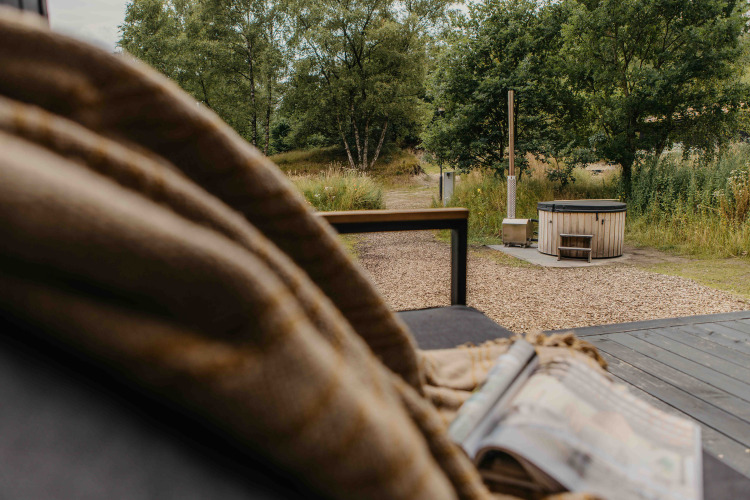 Vista desde la tiny house The Hills en Wilsumer Berge, Alemania, con bañera de hidromasaje y naturaleza.