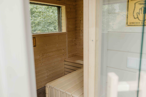 Binnenzicht van een houten sauna in de tiny house The Hills met raam in Wilsumer Berge, Duitsland.