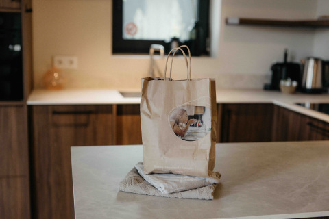 Papieren zak en handdoek op een aanrecht in de keuken van een moderne glamping accommodatie.