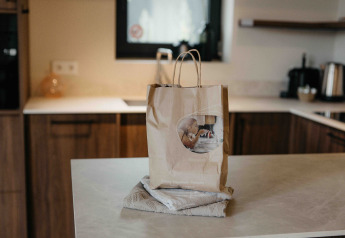 Papieren zak en handdoek op een aanrecht in de keuken van een moderne glamping accommodatie.