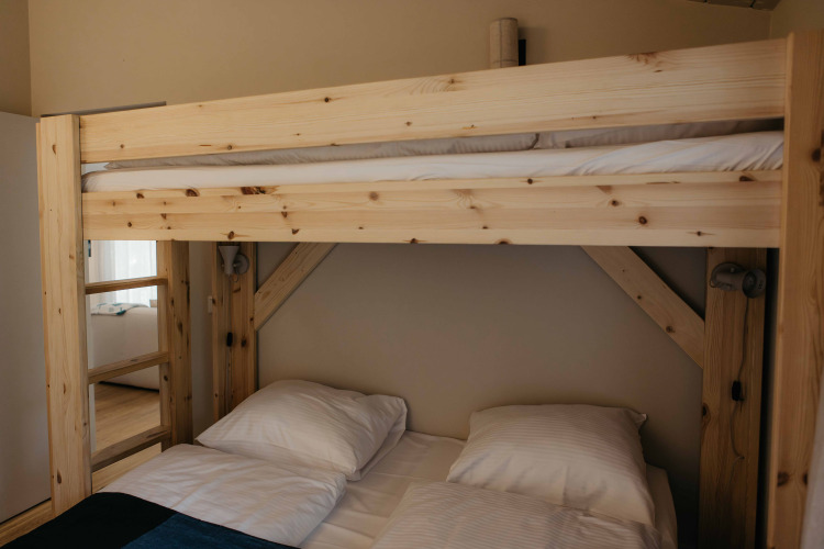 Litera de madera con ropa de cama en The Hills, una tiny house con jacuzzi y sauna en Wilsumer Berge, Alemania.