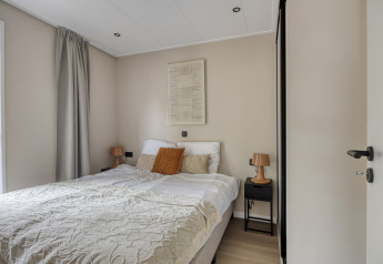 Moderne soveværelse i Heidehof 5 personer lodge på Bospark Ede, Holland, med dobbeltseng og natborde.