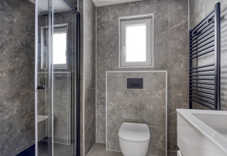 Modern bathroom at Heidehof 5 personen in Bospark Ede, Netherlands, with walk-in shower and marble tiles.