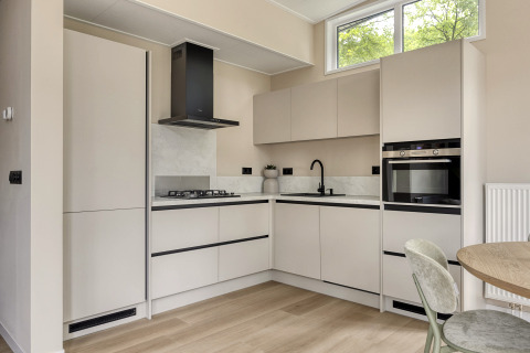 Moderne lichte keuken in Heidehof 5 personen lodge op Bospark Ede, Nederland, met grote ramen en apparaten.