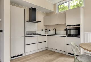 Moderne lichte keuken in Heidehof 5 personen lodge op Bospark Ede, Nederland, met grote ramen en apparaten.