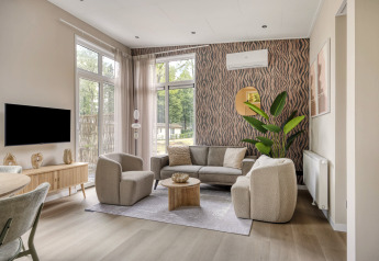 Salón moderno en Heidehof 5 personen, Bospark Ede, Países Bajos, con ventanales y decoración elegante.