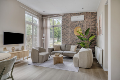 Salotto moderno presso Heidehof 5 personen a Bospark Ede, Paesi Bassi, con arredi eleganti e finestre ampie.