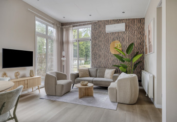 Salotto moderno presso Heidehof 5 personen a Bospark Ede, Paesi Bassi, con arredi eleganti e finestre ampie.