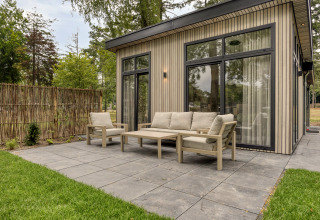 Buitenpatio met moderne tuinmeubelen bij Heidehof 5 personen lodge in Bospark Ede, Nederland.