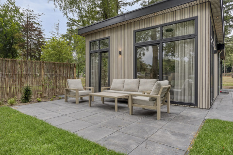Buitenpatio met moderne tuinmeubelen bij Heidehof 5 personen lodge in Bospark Ede, Nederland.