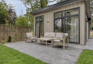 Terrazza esterna con arredi moderni al lodge Heidehof 5 persone nel Bospark Ede, Paesi Bassi.
