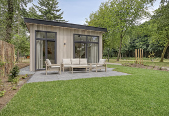 Moderne Lodge Heidehof 5 Personen im Bospark Ede, Niederlande, mit Terrasse und Gartenmöbeln in Natur.