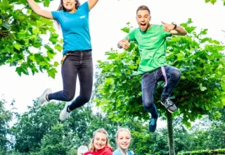 Four young adults playing outdoors at ’t Strandheem holiday park in Groningen, Netherlands, in summer.