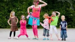 Bambini ballano allegramente con un’animatrice al parco vacanze ’t Strandheem a Groningen, Paesi Bassi.