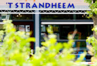 Eingangsschild des Ferienparks ’t Strandheem, umgeben von grünen Büschen in Groningen, Niederlande.