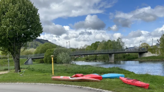 Kayak sull’erba vicino al fiume sotto un cielo nuvoloso presso Camping Gritt, Diekirch, Lussemburgo.