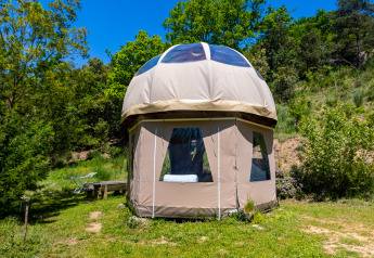 Tienda tipi burbuja única sin plomería en Camping Des Randonneurs, Francia, rodeada de naturaleza verde.