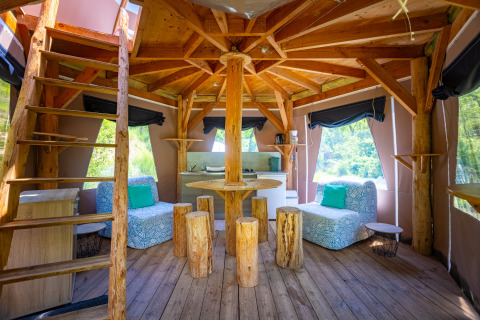 Interieur van een unieke bubbel-tipi tent zonder sanitair op Camping Des Randonneurs in Frankrijk, houten meubels.