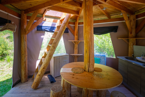 Interno di un tipì bolla unico senza impianti idraulici al Camping Des Randonneurs, con arredi in legno.