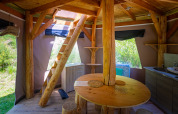 Interno di un tipì bolla unico senza impianti idraulici al Camping Des Randonneurs, con arredi in legno.