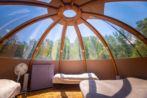 Interno di un tipì a bolla unico con letti sotto una cupola trasparente, Camping Des Randonneurs, Francia.
