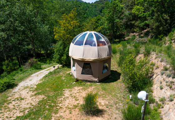 Tipi a bolla unico senza impianto idraulico, immerso nel verde tra alberi e natura incontaminata.