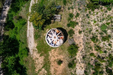 Vista aerea di una tenda tipi senza impianti idraulici, circondata dal verde al Camping Des Randonneurs, Francia.