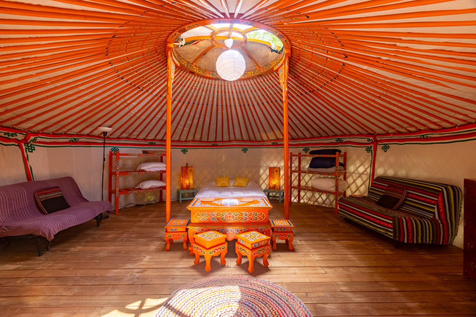 Kleurrijk traditioneel yurtinterieur met houten vloer bij Camping des Randonneurs in Occitanië, Frankrijk.