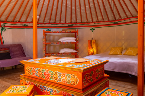 Interno colorato e tradizionale di una yurta di lusso al Camping des Randonneurs glamping in Occitania.