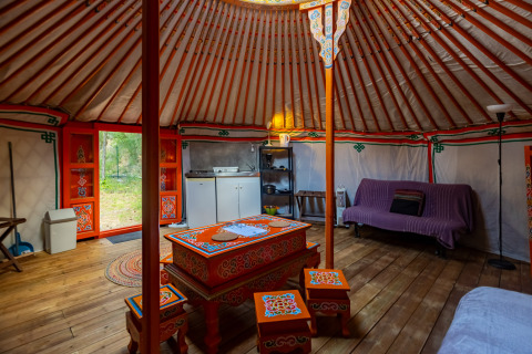 Indretning af en traditionel mongolsk jurte med farverig indretning på Camping des Randonneurs - Yurts Occitanië.