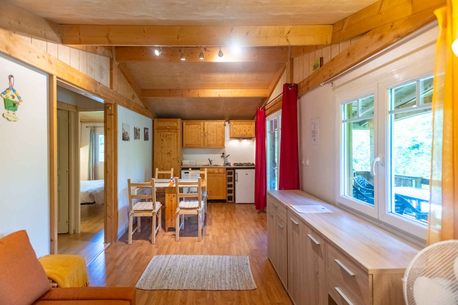 Gezellig houten interieur van het chalet bij Camping Des Randonneurs in Frankrijk, met eettafel en keuken.