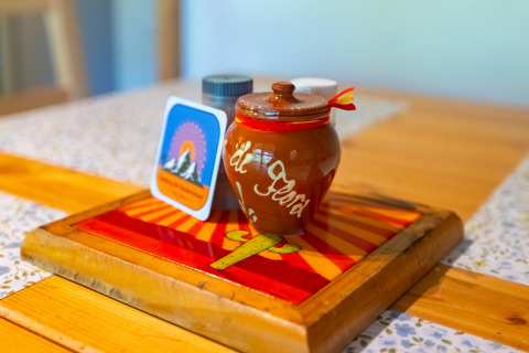 Colorful table with ceramic jar, spice containers, and mountain card at Chalet at Camping Des Randonneurs, France.