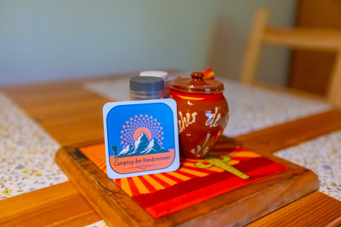 Table setting at the Chalet at Camping Des Randonneurs in France, featuring decor and a spice jar.