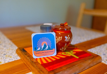 Table setting at the Chalet at Camping Des Randonneurs in France, featuring decor and a spice jar.