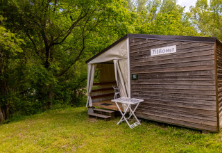 Safaritent Stacaravan Tithome bij Camping Des Randonneurs in Frankrijk, omgeven door groen bos.