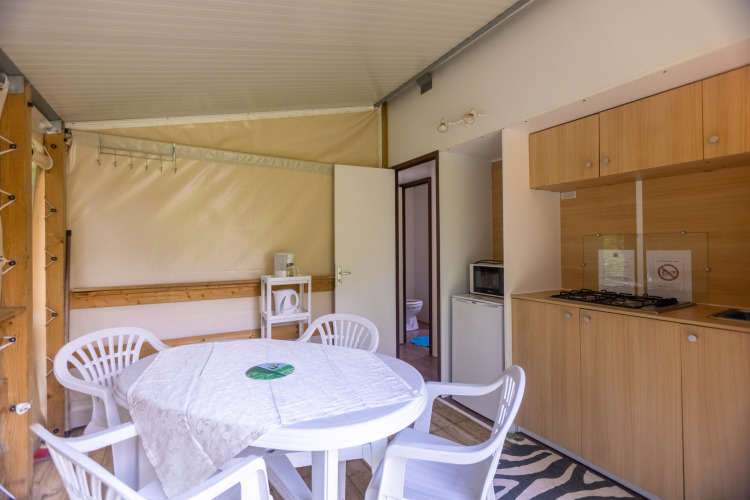 Interieur van de Stacaravan Tithome safaritent op Camping Des Randonneurs in Frankrijk, met keuken en eettafel.