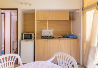 Angolo cucina nella tenda safari Stacaravan Tithome al Camping Des Randonneurs in Francia, con fornello e microonde.