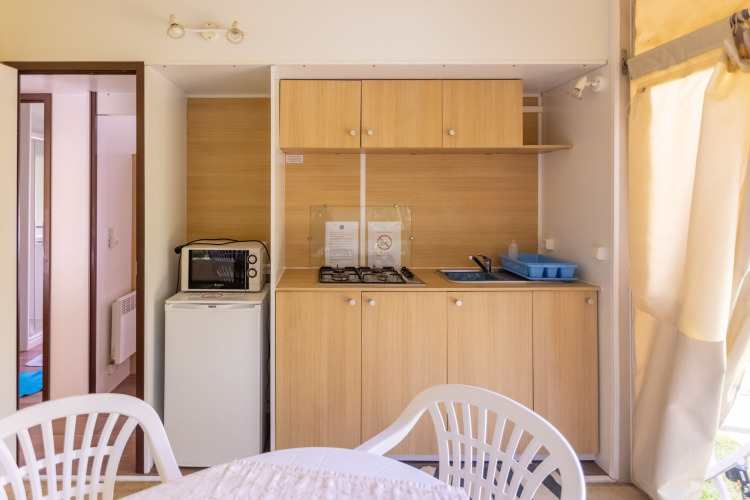 Espace cuisine du Stacaravan Tithome, tente safari au Camping Des Randonneurs en France, avec gazinière et micro-ondes.