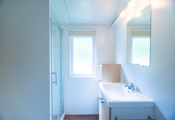 Bagno moderno e luminoso nella tenda safari Stacaravan Tithome al Camping Des Randonneurs in Francia.