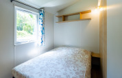 Camera luminosa in Stacaravan Tithome al Camping Des Randonneurs, Francia, con finestra e letto matrimoniale.