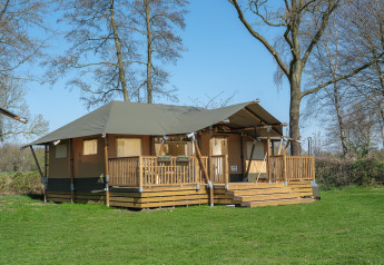 Safari tent Medley Lodge with veranda and hot tub at Recreation Park Den Blanken, Netherlands, in nature.