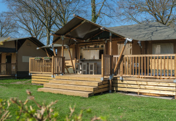 Medley Lodge safari tent with hot tub at Recreation Park Den Blanken, Netherlands, wooden deck visible.