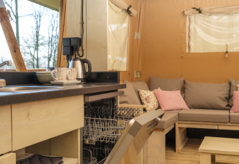Cuisine et salon d'une tente safari Medley Lodge avec jacuzzi au parc Den Blanken, Pays-Bas.