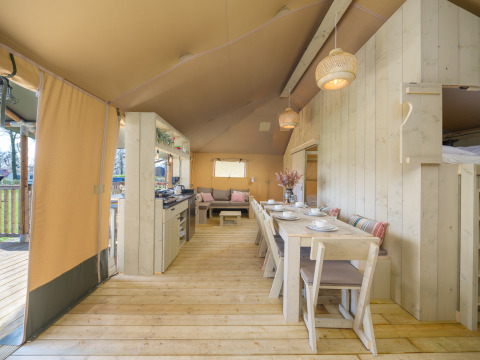 Interior de la tienda safari Medley Lodge con mesa de comedor y cocina en Recreation Park Den Blanken, Países Bajos.
