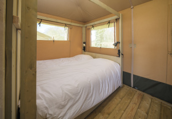 Camera con letto matrimoniale in tenda safari Medley Lodge, parco Den Blanken, Paesi Bassi, interno legno.