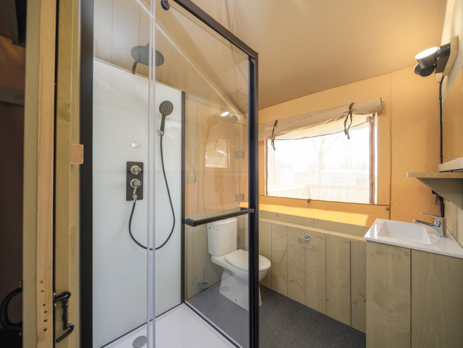 Baño en tienda safari Medley Lodge con ducha, inodoro y lavabo en el Parque Recreativo Den Blanken, Países Bajos.