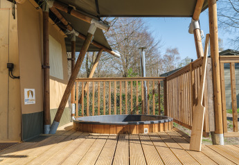Safaritent Medley Lodge met hottub op houten terras bij Recreatiepark Den Blanken in Nederland.