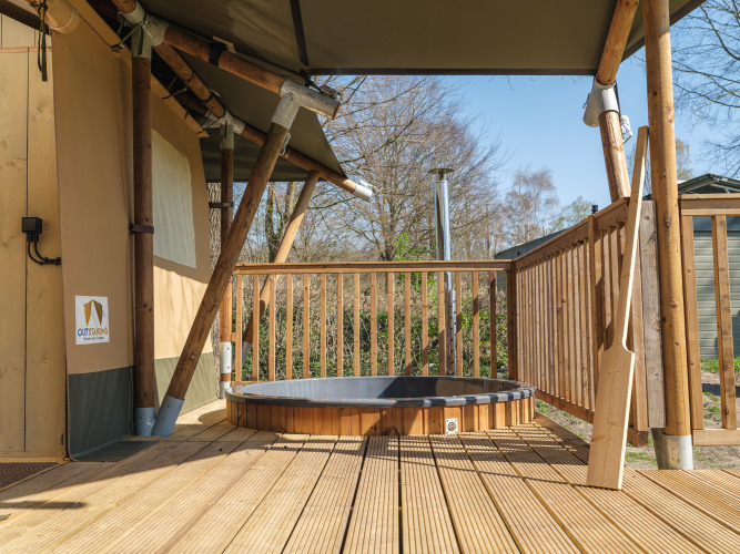 Tienda safari Medley Lodge con jacuzzi en terraza de madera en Recreation Park Den Blanken, Países Bajos.